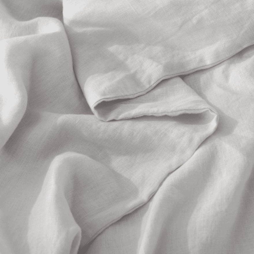Close-up of light gray European Flax Linen Duvet Cover fabric with folds
