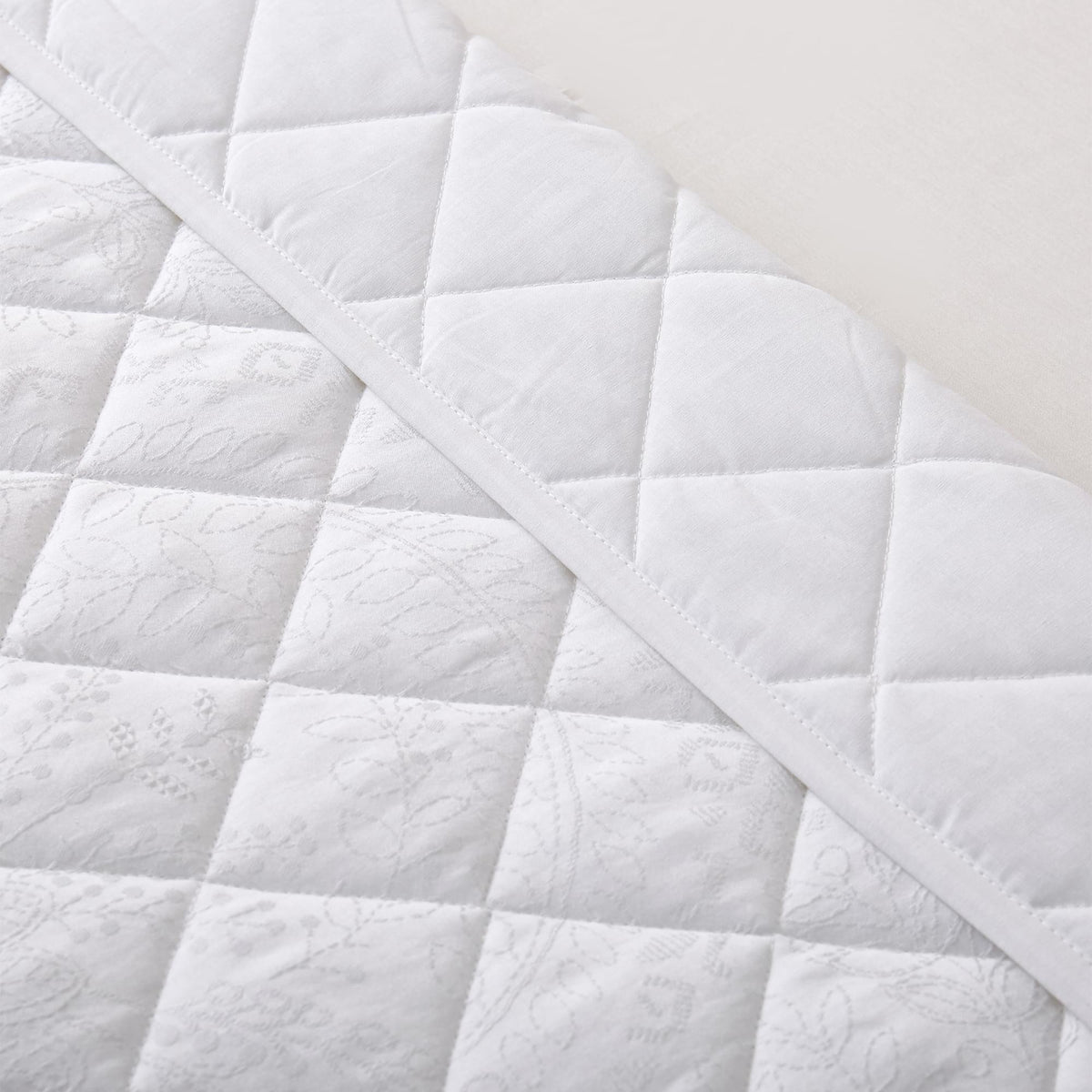 Close-up of a Timeless Heritage Woven Quilt Set White with a diamond pattern.