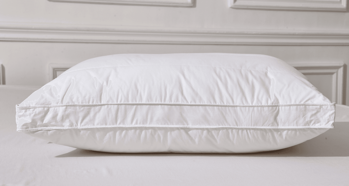 White piOrganic Cotton White Pillowllow on a bed with a neutral background