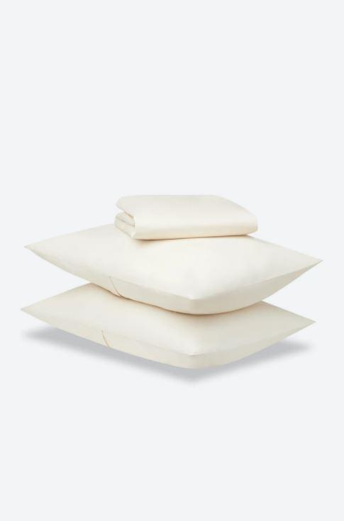 Stack of three white pillows on a light gray background