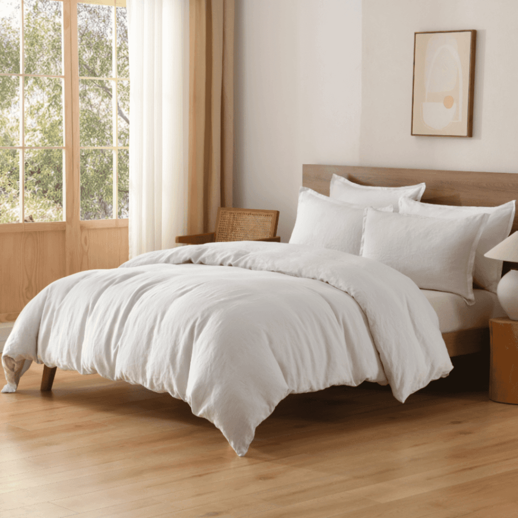 Neatly made bed with white European Flax Linen Duvet Cover in a bright bedroom