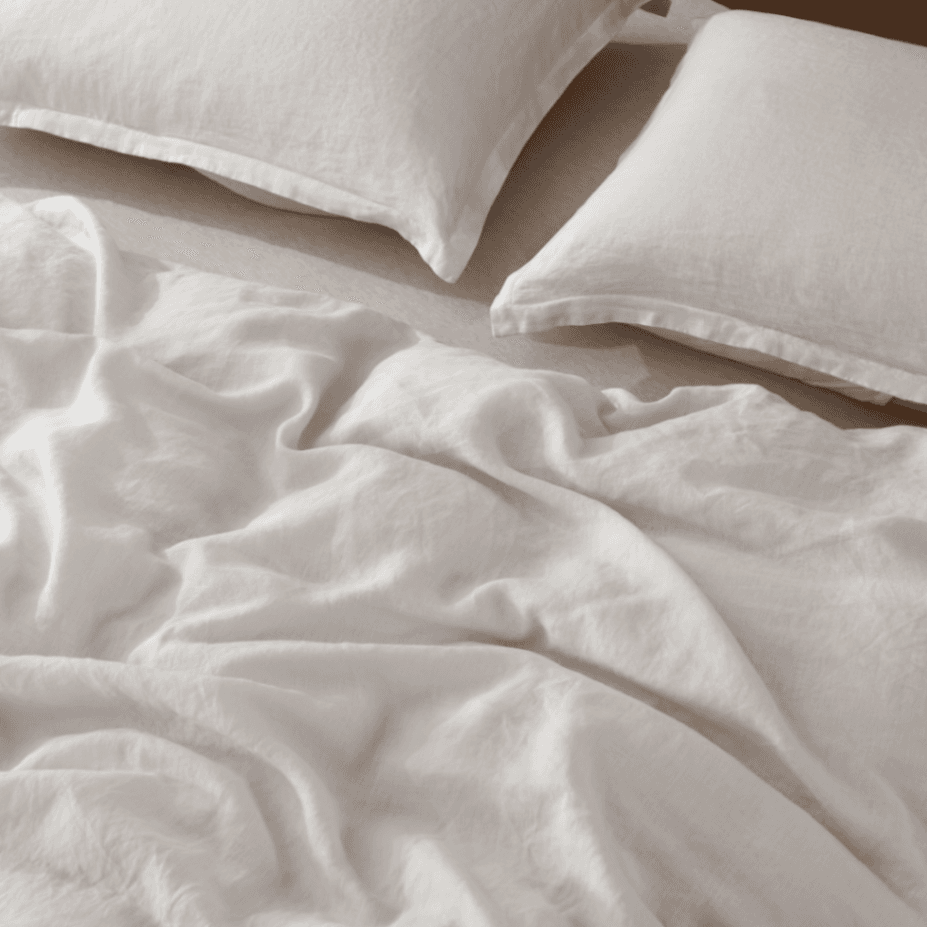 Close-up of white bedding with two pillows on a bed.