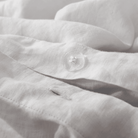 Close-up of a textured white fabric with a button