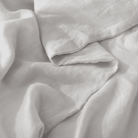 Close-up of light gray European Flax Linen Duvet Cover fabric with folds