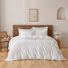 Neatly made bed with white bedding in a bedroom setting.