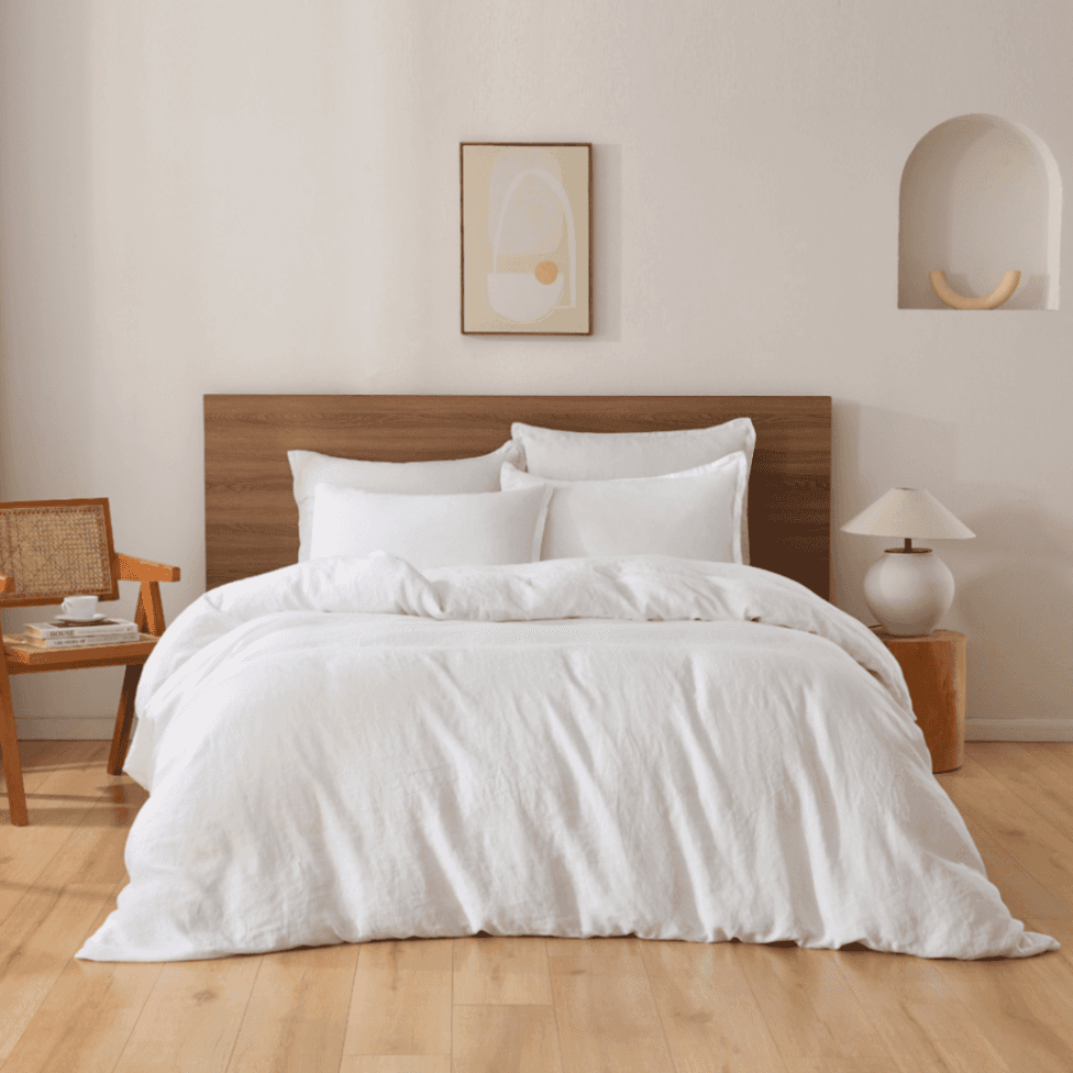 Neatly made bed with white bedding in a bedroom setting.