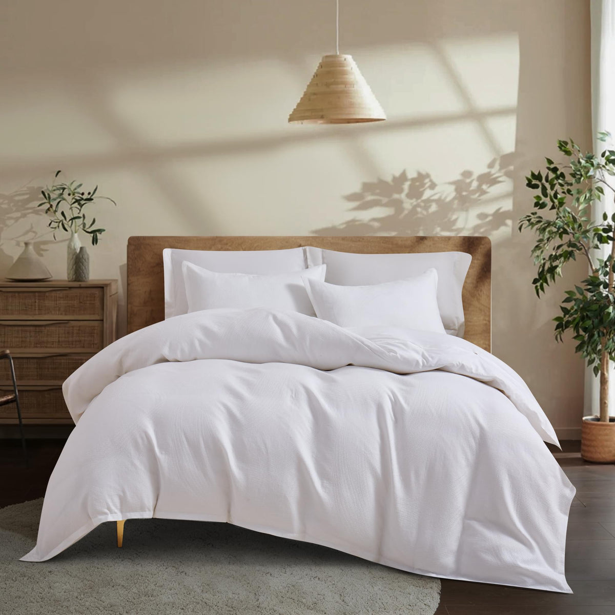 White Aurora Bloom Leaf Jacquard Duvet Cover Set White on a bed in a bedroom with plants and a lamp.