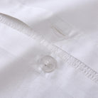 Close-up of a white Aurora Bloom Leaf Jacquard Duvet Cover Set White with a button and stitching details.