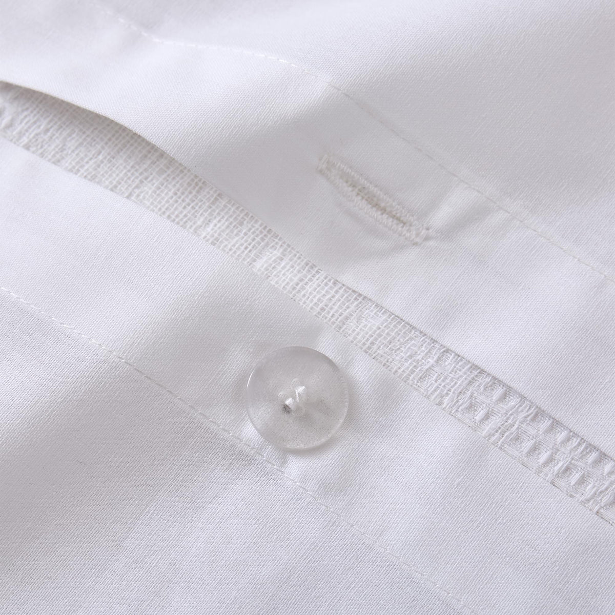Close-up of a white Aurora Bloom Leaf Jacquard Duvet Cover Set White with a button and stitching details.