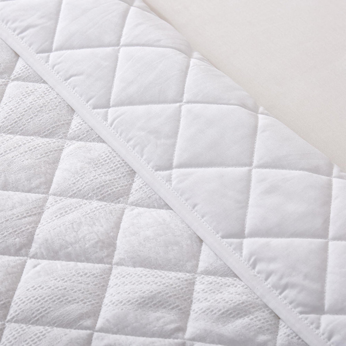Close-up of a white Aurora Bloom Leaf Jacquard Quilt Set White on a plain background