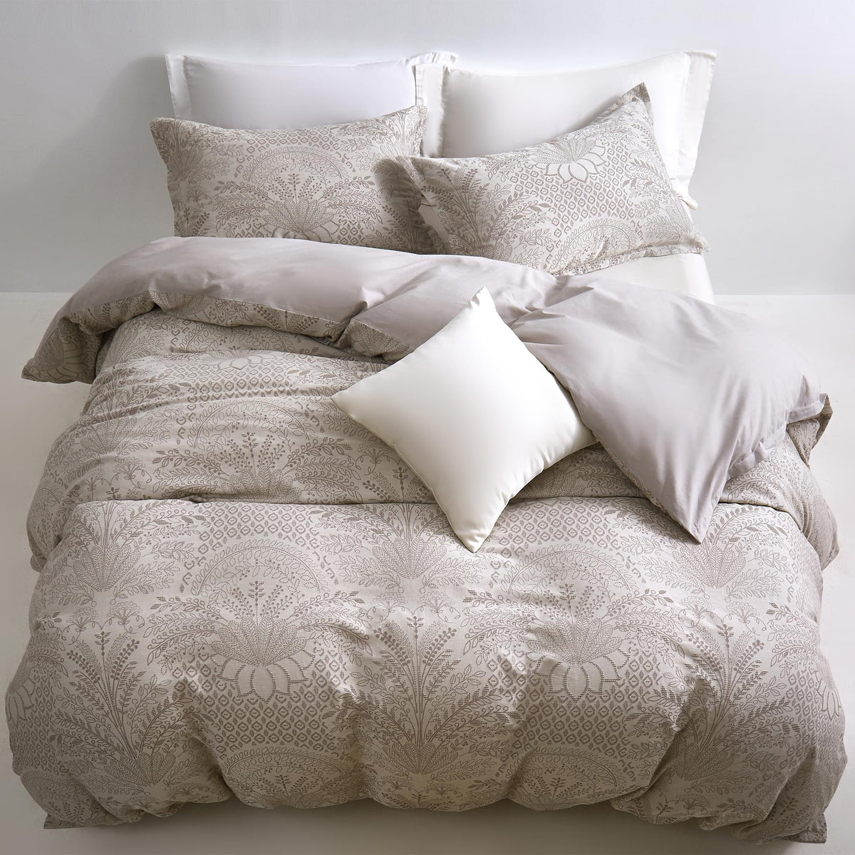 Timeless Heritage Woven Comforter Set with pillows on a bed against a white wall