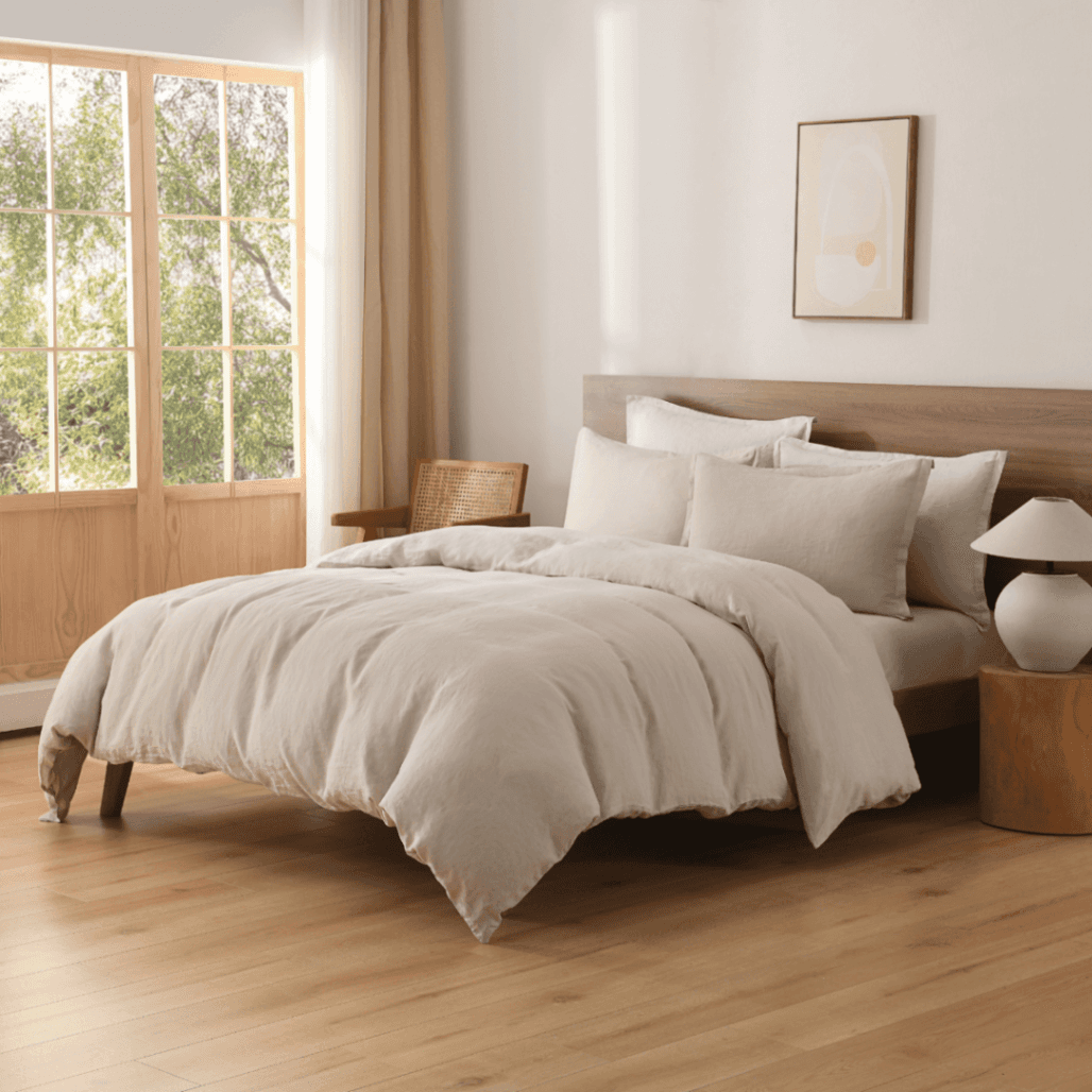 Neatly made bed with beige European Flax Linen Duvet Cover in a bright bedroom