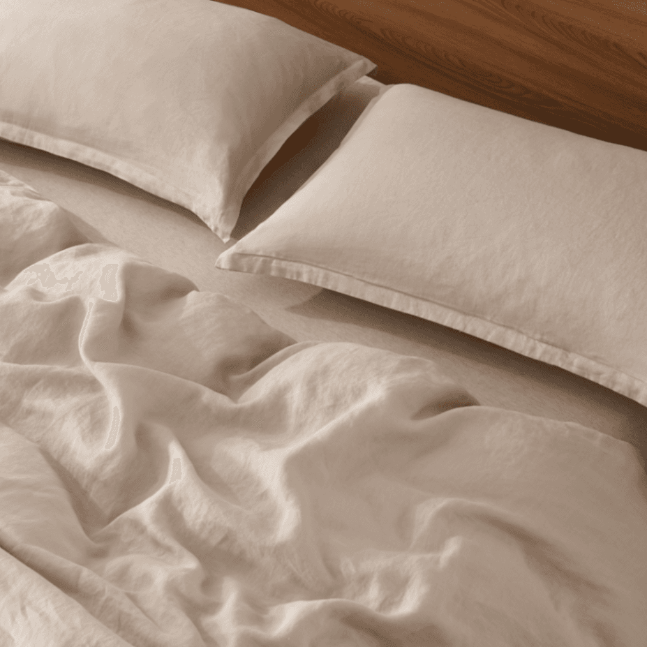 Beige European Flax Linen Duvet Cover set with two pillows on a wooden bed frame.
