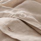 Close-up of beige European Flax Linen Duvet Cover with a button
