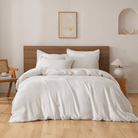 Neatly made bed with white European Flax Linen Duvet Cover in a bedroom setting.