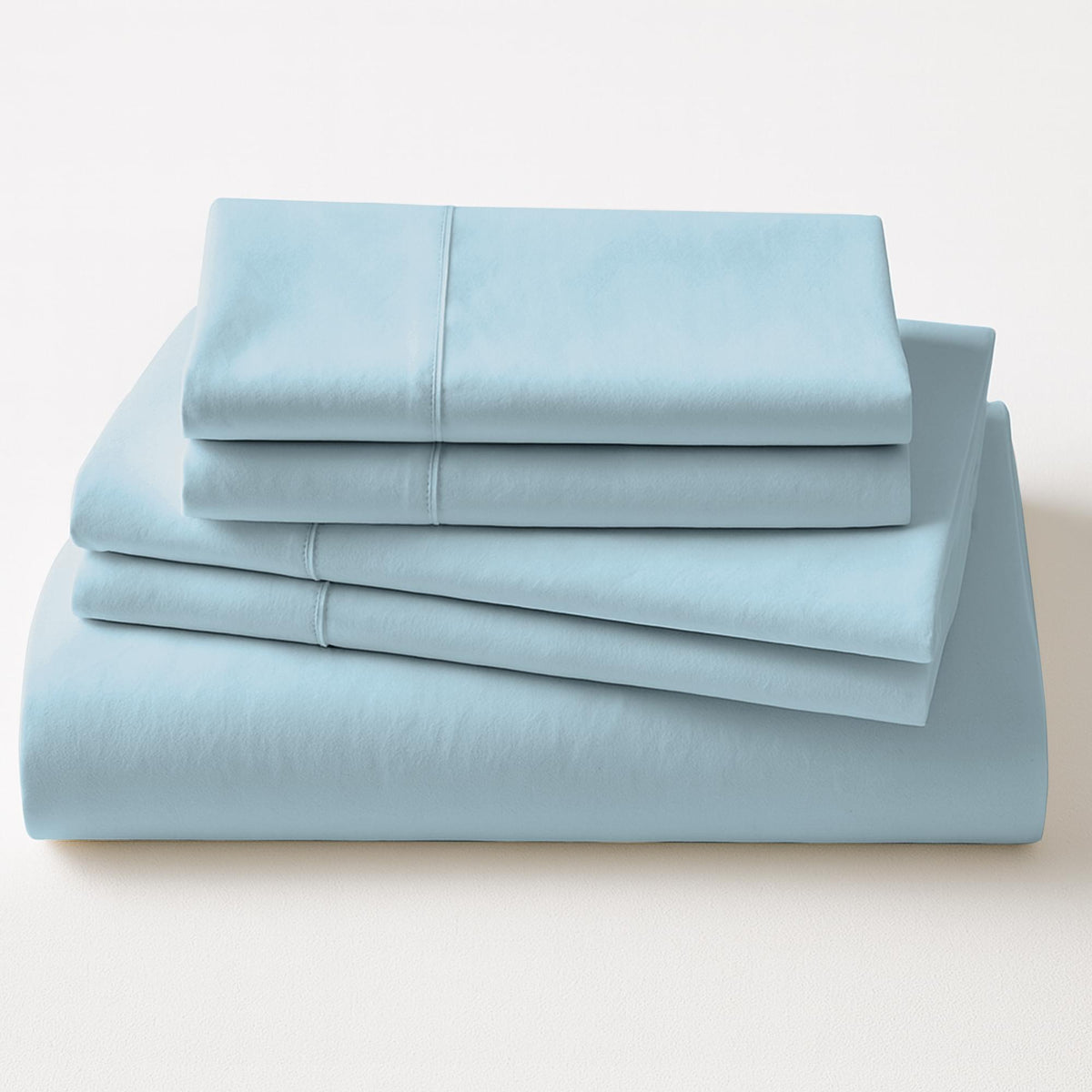 Folded light blue bed sheets on a white background
