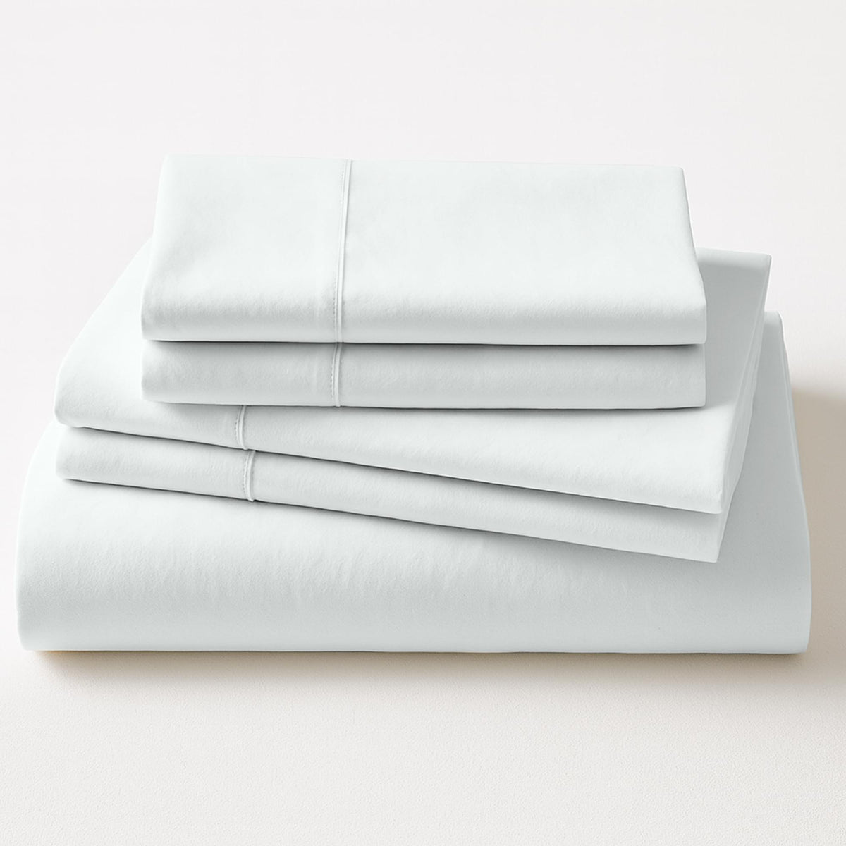 Stack of light gray bed sheets on a white background
