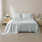 White bedding set on a bed in a minimalistic bedroom setting