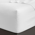 White fitted 100% Cotton Sheet Set 400 Thread Count on a bed corner with a plain background