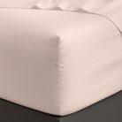 White satin Organic Cotton Sheet Set 400 Thread Count corner on a bed with a dark surface