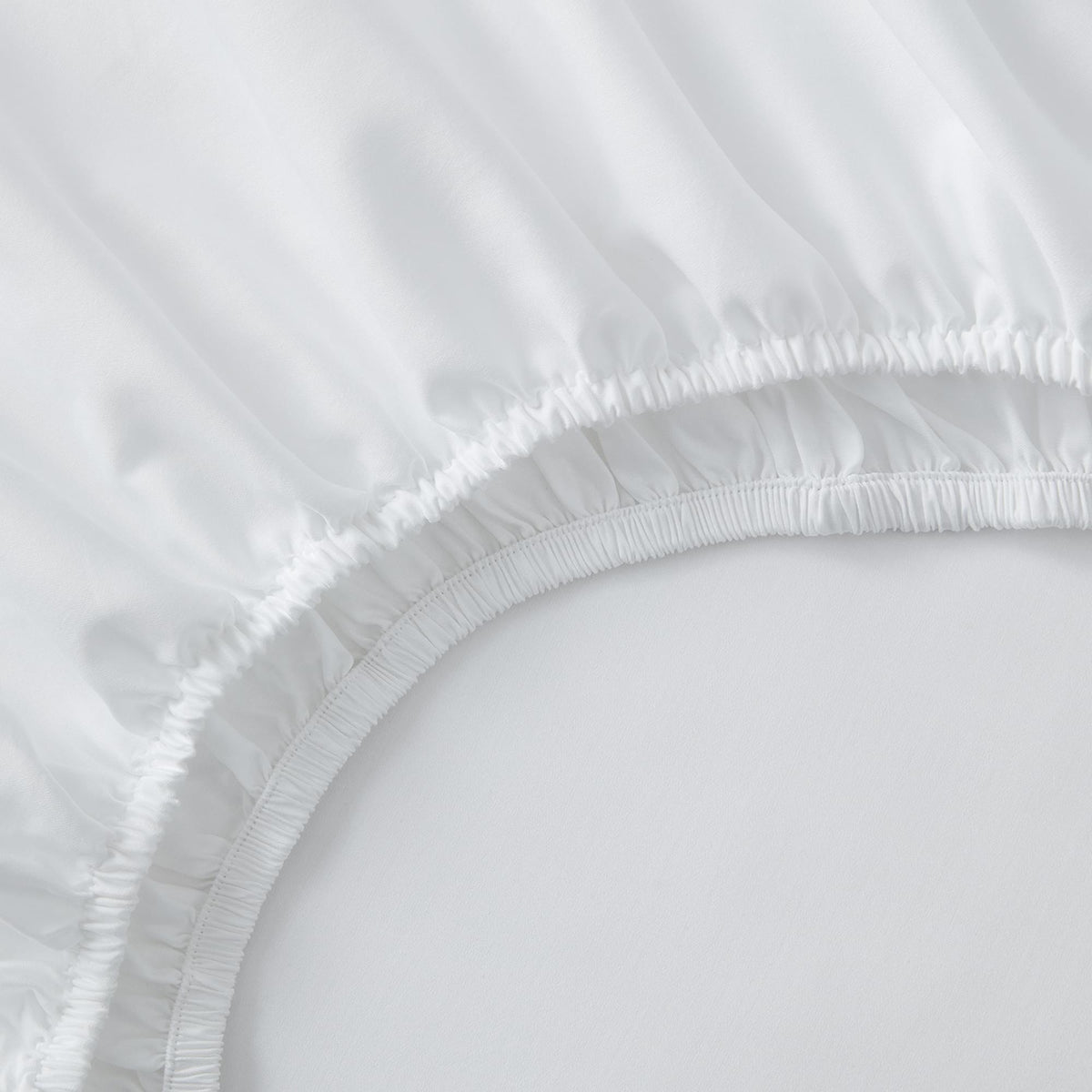 Close-up of a white fitted sheet on a bed
