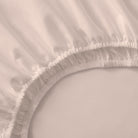 Close-up of a fitted sheet with ruffled edge on a bed.