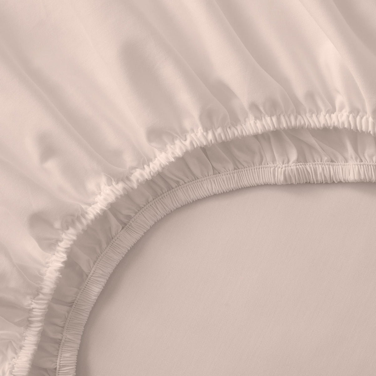 Close-up of a fitted sheet with ruffled edge on a bed.