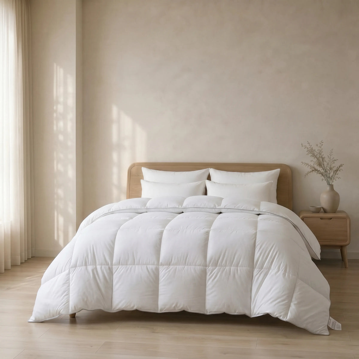White Down Alternative Gel Microfiber Duvet on a bed in a bedroom with a wooden nightstand and plant.