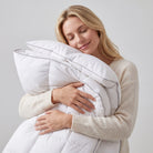 Woman holding a white Down Alternative Gel Microfiber Duvet against a plain background