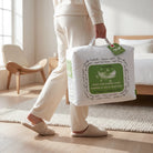 Person holding a down and feather Down and Feather Duvet packaging in a bedroom setting