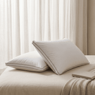 Two Down Alternative Gel Microfiber Pillow on a bed with light curtains in the background