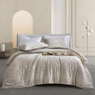 Neatly made bed with beige Timeless Heritage Woven Duvet Cover Set and pillows in a modern bedroom setting.