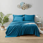Blue bedding set on a bed in a bedroom with decorative elements.