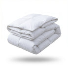 A folded white quilted comforter or duvet shown floating against a clean white background with a soft shadow underneath.