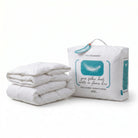 A folded white goose feather duvet next to its white branded storage bag on a clean white background. The bag features a teal graphic of a feather and text reading 'NEWSEASON goose feather duvet'.