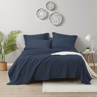 Navy blue bedding 600 Thread Count Cotton Bed Sheet Set on a bed in a bedroom with decorative plates on the wall.