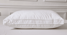 White piOrganic Cotton White Pillowllow on a bed with a neutral background