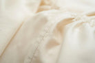 Close-up of beige Organic Cotton 500 Thread Count Luxuriously Soft Sheet Set with a focus on texture and stitching.