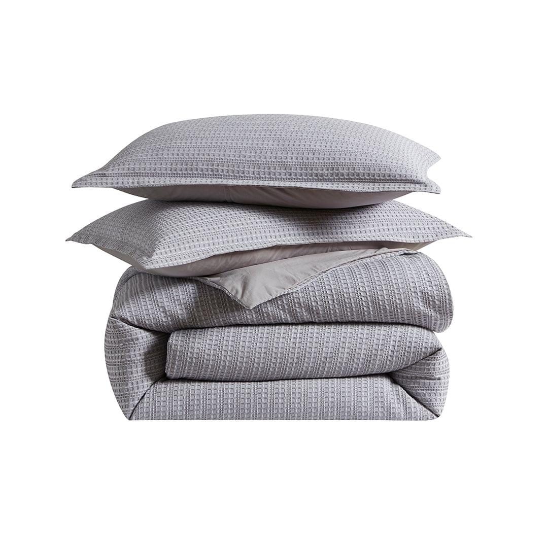 Gray textured Seersucker Euro Sham with a comforter and two pillows on a white background