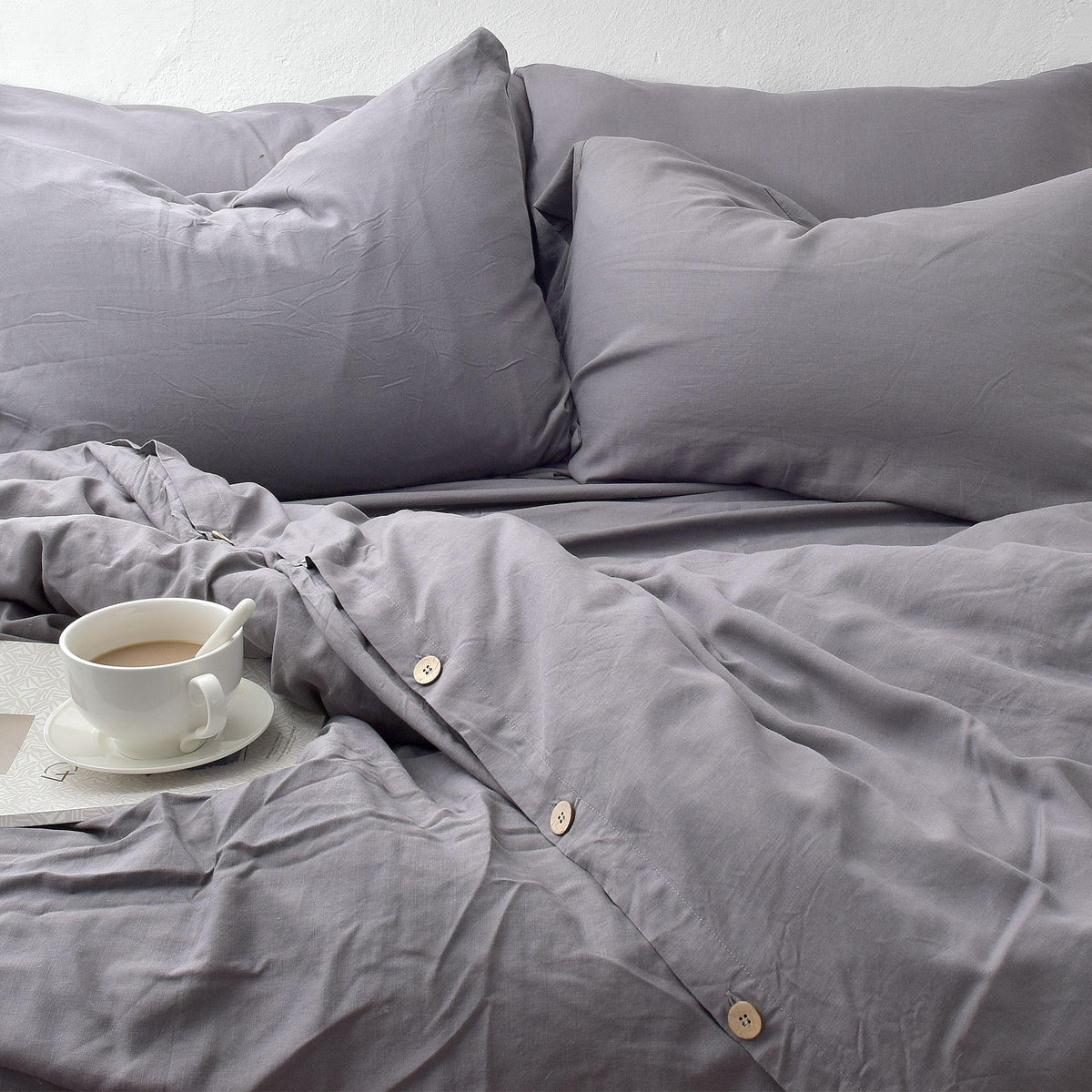 Gray bedding and Bamboo Linen Pillowcase Pairs with a cup of coffee on a white surface