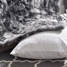 Gray textured Hug Me Faux Weighted Throw Blanket draped over a surface with a geometric-patterned pillow underneath.
