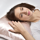 Woman lying on a pink pillow with a neutral background