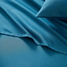 Blue satin pillowcase on a matching blue fabric background