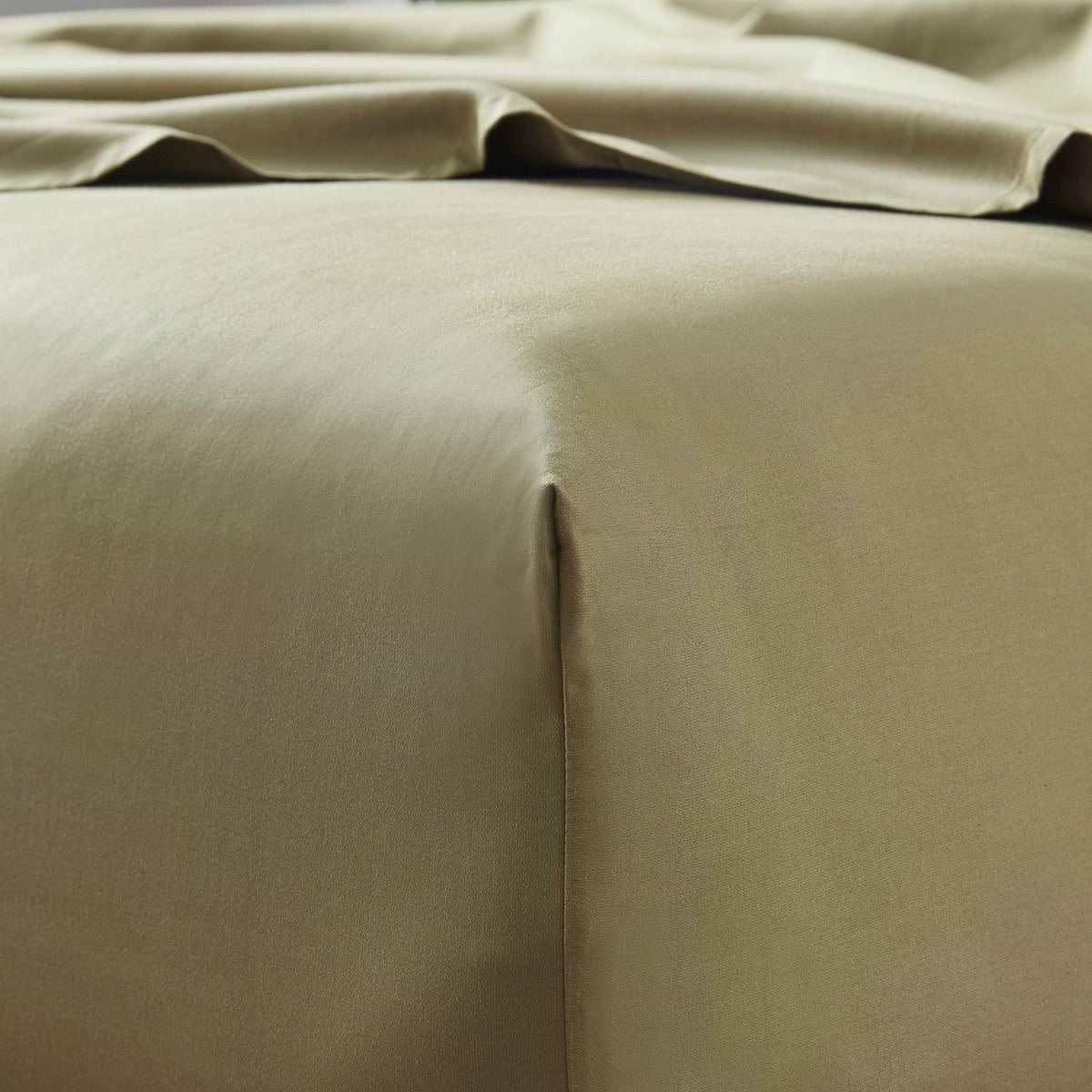 Close-up of beige bed sheets with a slight crease