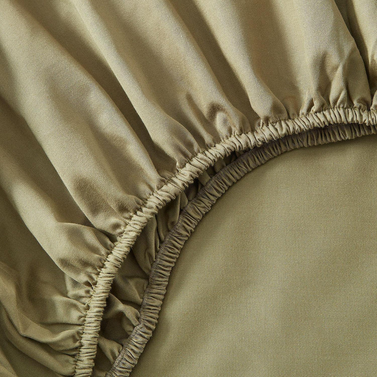 Close-up of beige fitted sheet with elasticized edge