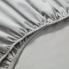 Close-up of a fitted sheet with ruffled edge on a bed.