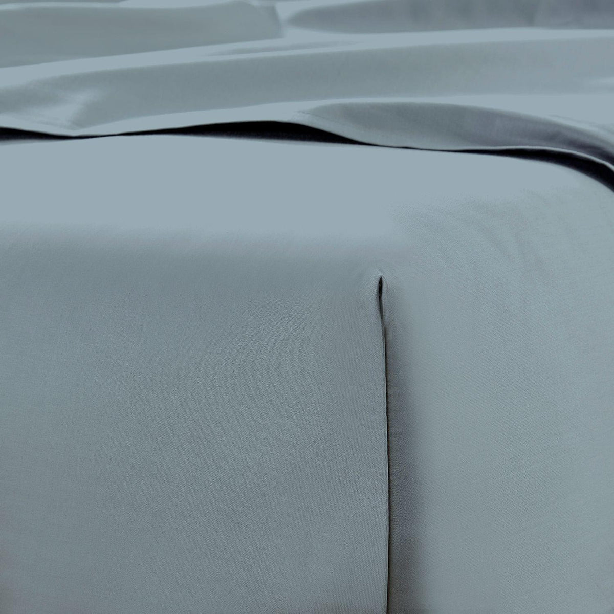 Close-up of light gray bedding with a subtle texture
