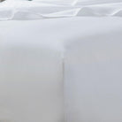 Close-up of a white satin pillow with a soft texture.