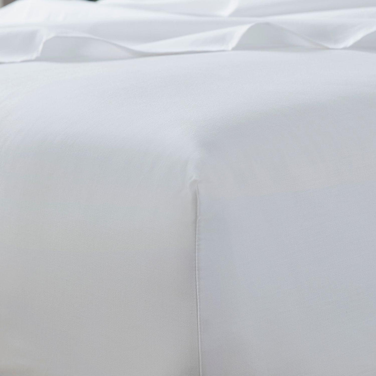 Close-up of a white satin pillow with a soft texture.